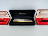 three pens in a case sitting on a table next to each other