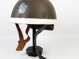 an old helmet with a sticker on it sitting on top of a stand