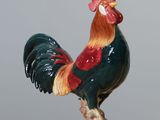 a figurine of a rooster on a wooden table