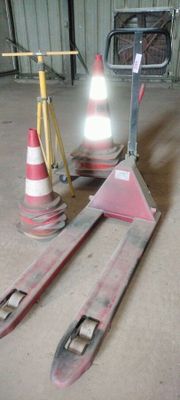 a pair of skis sitting on the ground next to a traffic cone