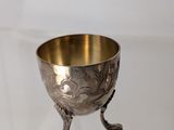 an antique silver plated cup on a stand on a white background