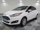 la ford fiesta blanche est garée dans une pièce au sol à carreaux