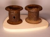 two vases sitting on a wooden stand on a white surface