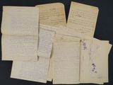 several old handwritten papers are piled on top of each other