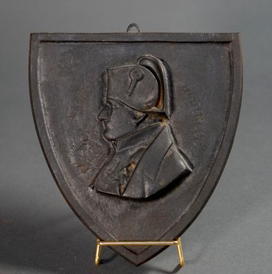 a bronze plaque of a man wearing a helmet on a stand