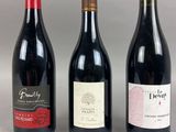three bottles of wine are lined up on a table
