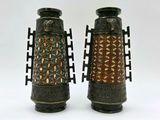 two vases sitting side by side on a white surface