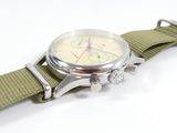a close up of a watch with a green strap