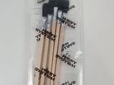 un lot de trois pinceaux dans un sachet en plastique posé sur une surface blanche