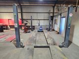 a picture of a garage with two lifts in it
