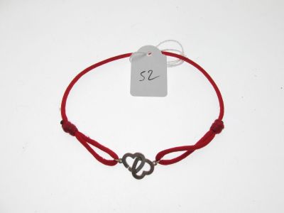 un gros plan d'un bracelet en ficelle rouge orné d'un cœur