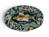 une assiette avec un poisson dessus, posée sur une table