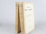 an old book sitting on top of a table next to a white wall