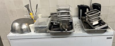 Plusieurs casseroles et poêles sont posées sur une cuisinière dans une cuisine.