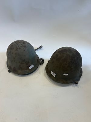 two helmets sitting on top of each other on a white surface