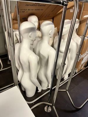 de nombreux mannequins blancs assis sur un chariot dans une pièce