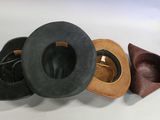 several hats are lined up on a white surface with a pair of scissors in the background