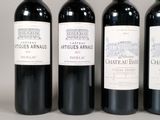 three bottles of red wine are lined up on a table