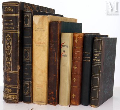 several old books are stacked on top of each other on a table
