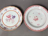 two plates with floral designs on them are sitting on a table