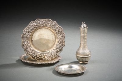 un plateau en argent et un vase en argent posés sur une table