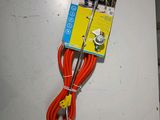 une rallonge rouge et jaune fixée à un mur blanc