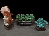 trois figurines chinoises sculptées représentant des animaux et des plantes, posées sur une table