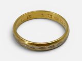 gros plan d'une bague en or sur une surface blanche