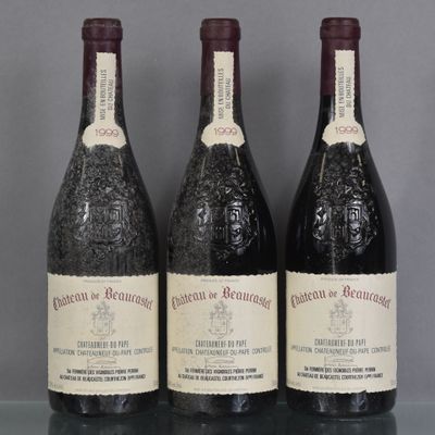 trois bouteilles de vin sont posées sur une étagère en verre devant un fond gris