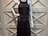 un mannequin vêtu d'une robe noire et d'un chapeau de paille
