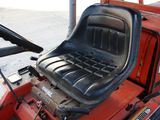 a red tractor with a black seat on the back of it