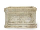 une boîte en pierre sur laquelle figurent des inscriptions sur une surface blanche