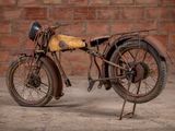 a old motorcycle that is parked in front of a brick wall