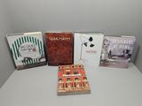 Quatre livres sont posés sur une table devant un mur blanc.