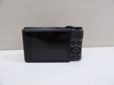 a small black camera sitting on a white table