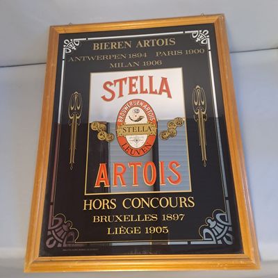 une affiche sur le mur où l'on peut lire « Stella Artois »