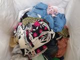 a pile of clothes in a plastic bag on a bed