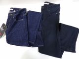 three pairs of blue jeans are hanging on a white wall