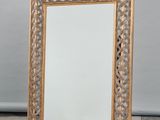 an image of a gold framed mirror sitting on a checkered floor