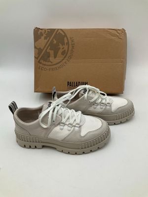 un gros plan sur une paire de chaussures avec une boîte en arrière-plan