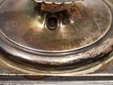 a close up of a silver plate with a flower on it
