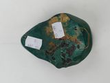 a green rock with tags on it sitting on a white surface