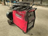 a red welding machine with a bunch of hoses on top of it
