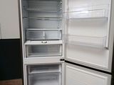 a white refrigerator with its door open on a wooden floor