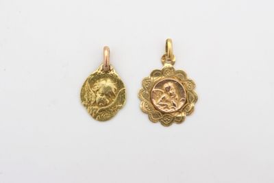 une paire de pendentifs en or représentant la tête d'un homme et d'une femme