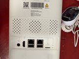 a white router with a cable connected to it on a red table