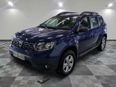 une photo d'une dacia bleue garée sur un sol en damier