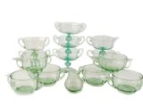 douze tasses et soucoupes en verre vert sont disposées en pyramide