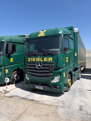 deux camions verts garés l'un à côté de l'autre sur un parking