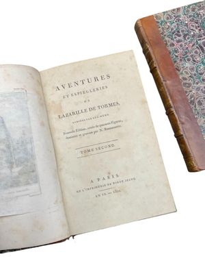 an old book sitting open on top of a table next to an old book